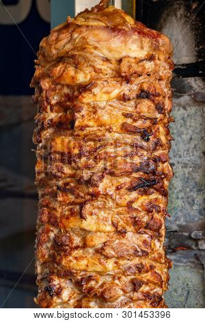 Delicious Slabs Of Skewered Fast Food Shawerma Chicken And Lamb Meat Turn Side By Side On A Spit.