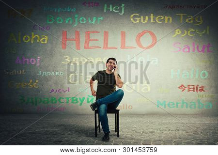 Casual Man Seated On A Chair Talking On Mobile Phone. Happy Manager Speaking Different Languages Wit