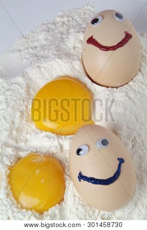 Broken Eggs Isolated Over The Flour On White Background
