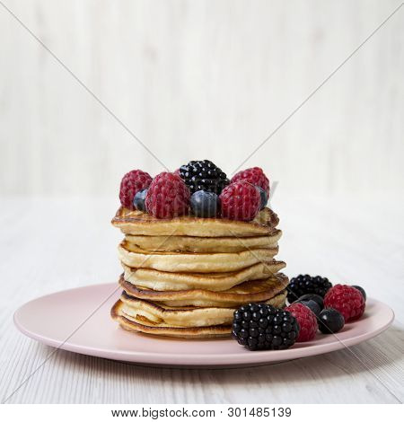 Tatsy Pancakes With Berries On A Pink Plate Over White Wooden Surface, Side View. Close-up.