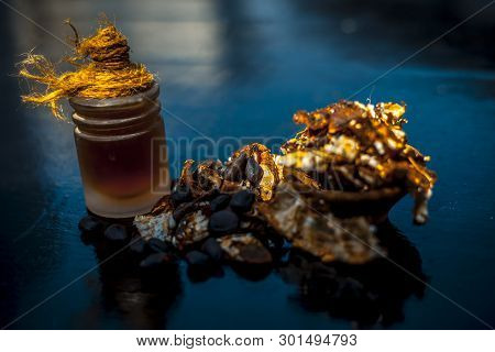 Raw Organic Amli Or Tamarind Or Imli In A Clay Bowl On Wooden Surface With Its Extracted Herbal Esse