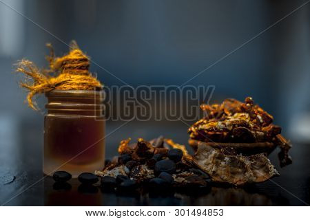 Raw Organic Amli Or Tamarind Or Imli In A Clay Bowl On Wooden Surface With Its Extracted Herbal Esse