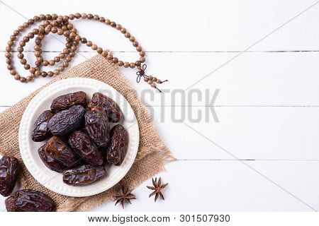 Ramadan Food And Drinks Concept. Wood Rosary, Milk And Dates Fruit On A White Wooden Table Backgroun