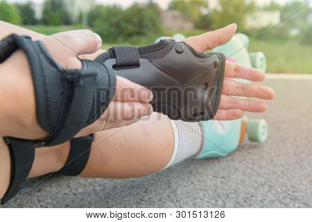Woman rollerskater wearing wrist guards protector pads on her hand