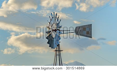 Clear Panorama Windpump With A Snow Covered Mountain And Cloudy Blue Sky In The Background