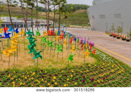 Muju,south Korea; May 1, 2019: Colorful Pinwheels And Flowers In Trimmed Lawn Of World Taekwondo Fed