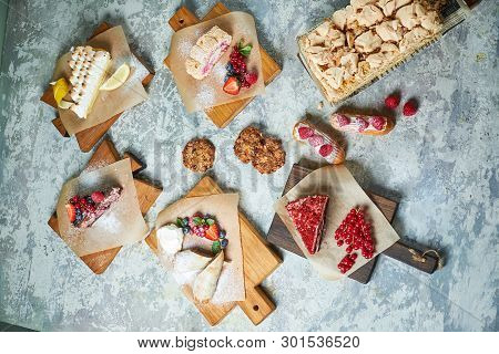 Assorted Sweet Desserts. Top View. Gray Textured Background. Beautiful Serving Dishes. Dessert. Food