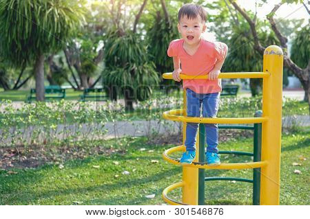 Cute Little Asian 2 - 3 Years Old Toddler Boy Child Having Fun Trying To Climb On Climbing Frame At 
