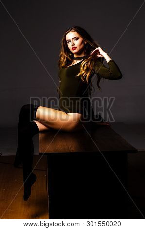 Beautiful Dancer. Girl Model. The Girl Sits In A Hat And Sits On A Table. Girl In A Beautiful Underw
