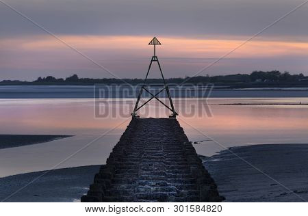 A Cardinal Sailing Marker At Sunset On A Calm Tide On The Loughor Estuary, Llanelli, South Wales, Uk