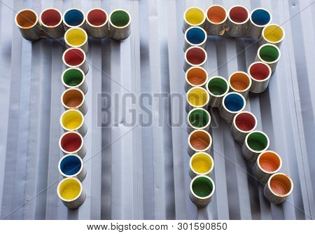 Tr Letters Like Abbreviation Made By Colorful Tin Cans Are On Dark Wall As Background. Using Combina