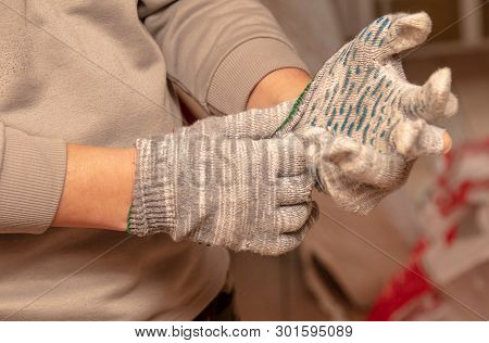 Worker Takes Off Gloves From Hands At A Construction Site.