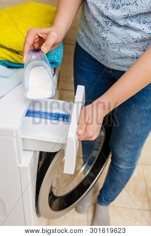 Washing Powder Detergent And Measuring Cup Pouring Into Machine. Household Duties, Clothes Laundry O