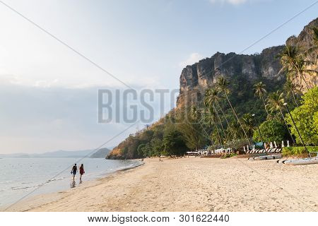 Young Couple Walking On Pai Plong Beach At Sunset In Krabi Province, Thailand.