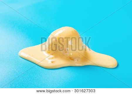 Side View Mango Flavor Ice Cream Ball In A Melting Process On Blue Background