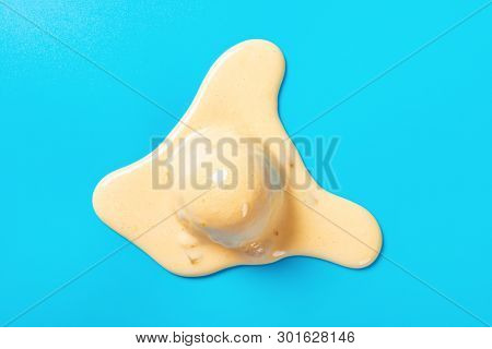 Top View Mango Flavor Ice Cream Ball In A Melting Process On Blue Background