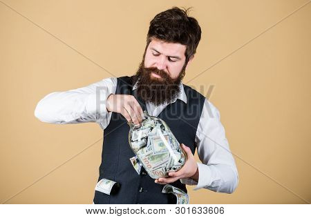 Making An Investment. Businessman Taking Cash Money Out Of Glass Jar For Investing Activities. Beard