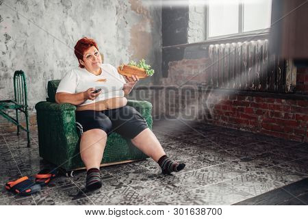 Overweight woman watches TV, bulimic, fatty