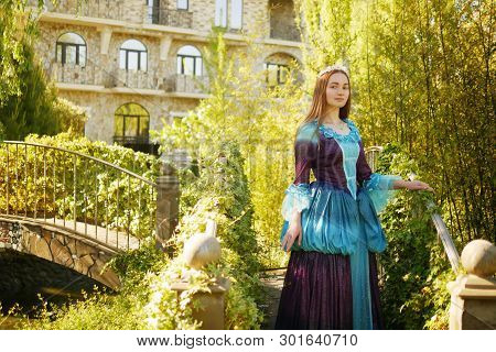 Girl Animator Dressed As A Medieval Princess On The Background Of The Castle In A Beautiful Park