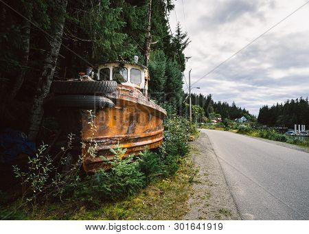 A Rusty Abandoned Fishing Boat By Forest