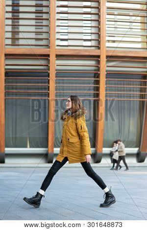Fashion model walking and posing outdoor. Young blond caucasian woman posing winter outdoo. Beautiful girl, urban portrait.