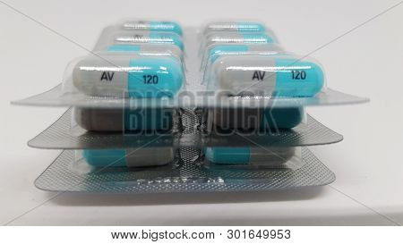 3 Sealed Packets Of Blue And Grey Tablets Stacked On Top Of Each Other.