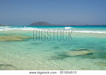 Beach Corralejo On The Canary Island Fuerteventura, Spain. View On The Islands Lobos And Lanzarote.