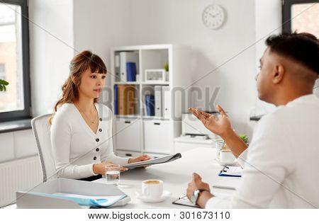 new job, hiring and employment concept - recruiter having interview with asian female employee at office