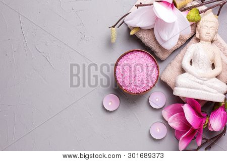 Sea Salt, Burning Candles, Buddha And Pink Magnolia Flowers On Grey Textured Background. Spa Concept