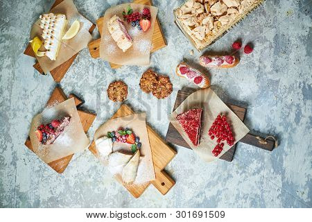 Assorted Sweet Desserts. Top View. Gray Textured Background. Beautiful Serving Dishes. Dessert. Food