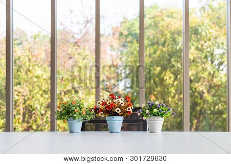 Grop Of Bouquet Colorful Artificial Flower In Vase On Modern Table With Nature Outside Long Glass Wi