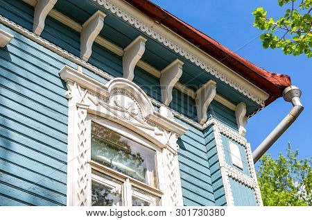 Russian Traditional Wooden Architecture. Facade Of An Old House Decorated With Wooden Carvings, Plat