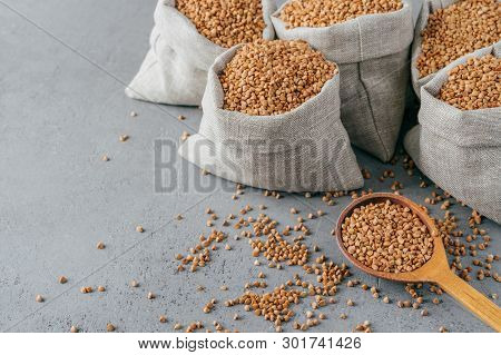Eco Food And Clean Eating Concept. Buckwheat In Small Linen Bags. Wooden Spoon Filled With Protein P
