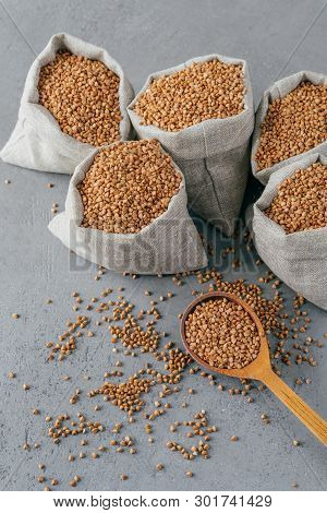 Gluten Free Product. Vertical Shot Of Dry Brown Buckwheat For Vegetarians. Sacks With Cereals. Woode