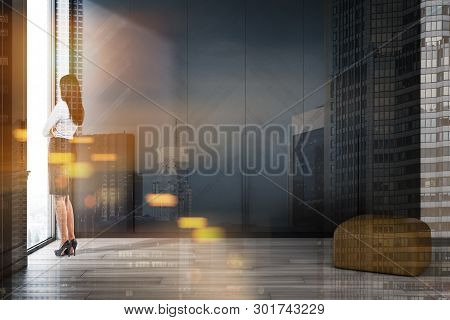 Woman In Business Suit Standing In Minimalistic Living Room Interior White Walls, Wooden Floor, Comf