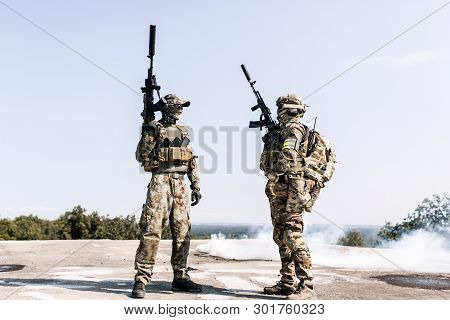 Two Armed Men In Camouflage With A Sniper Gun In Hand