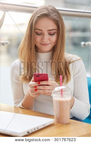 Vertical Portrait Of Concentrated Smart Clever Beautiful Woman Wearing White Casual Shirt, Having Re