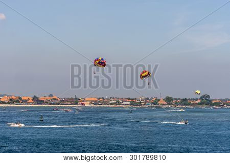 Bali, Indonesia - February 25, 2019: Outside Benoa Port. Colorful Parasailing Activity In Front Of T