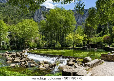 South Of France, View On Small Touristic Provencal Town Of Fontaine-de-vaucluse With Emerald Green W