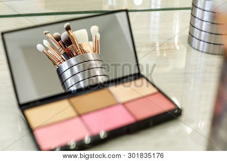 Makeup Brushes Are Reflected In A Palette Mirror With Shadows