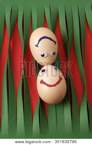 Eggs With Eyes Isolated On Striped Green Paper Background