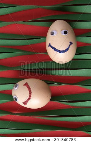 Eggs With Eyes Isolated On Striped Green Paper Background