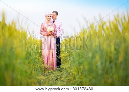 Smiling Young Islamic Couple Portrait On Sunflowers Field