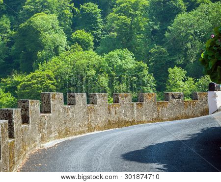 Rocky Asphalt Road With High Stone Fence Leading To Warfleet Lodge, Dartmouth, United Kingdom
