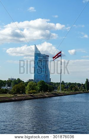 Modern Glass Skyscraper Of Swedbank Office And Latvian Flag Against Blue Sky In Riga City, Latvia, J