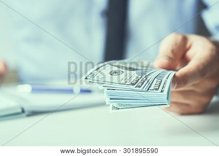 Man Giving Money Us Dollar Banknotes And Holding Cash In Hands. Money Credit Concept. Toned Picture.