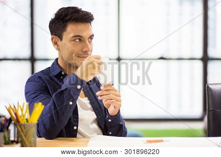 Creative Designers Man Take A Break And  Drinking Coffee From A Cup  In The  Modern Office . Busines