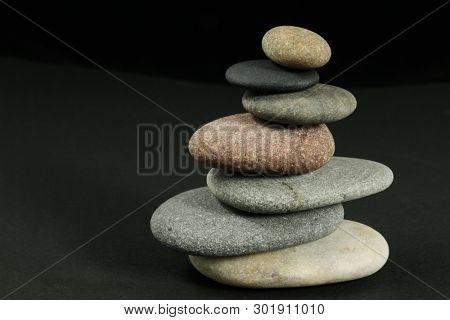 Seven pebbles pyramid in staggered rows, over dark