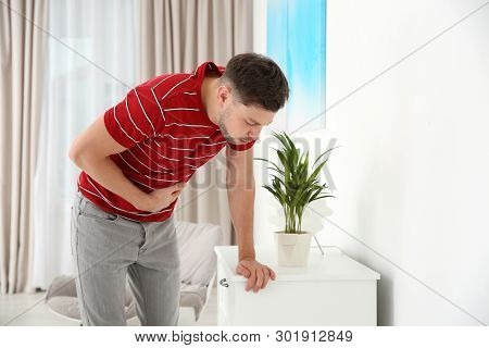 Young Man Having Nausea At Home. Space For Text