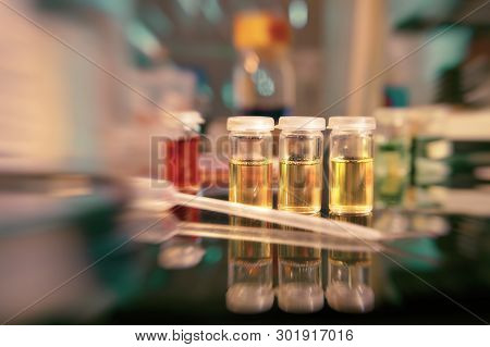 Microbiology Background. Liquid Bacterial Cultures On The Bench, Shallow Dof, Focus On The Three Yel